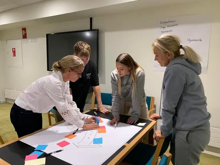 3 kvinder og en mand omkring et bord