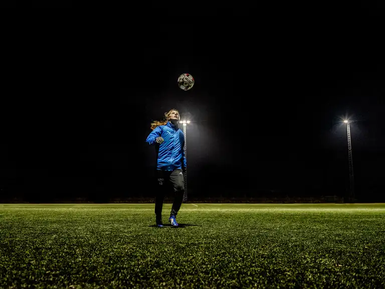En fodboldspiller på en fodboldbane med lys på